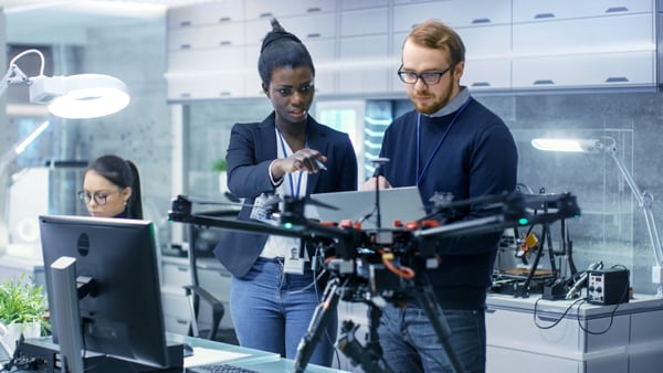 People working on a quadcopter in a lab